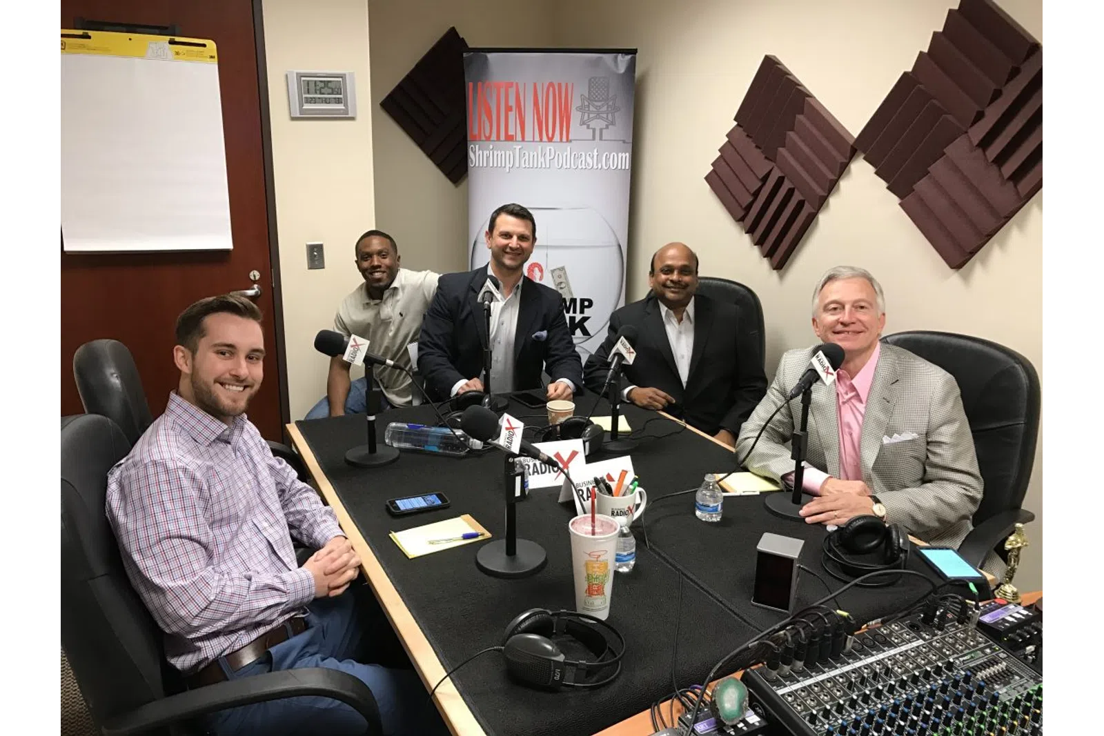 a group of men sitting around a table with microphones