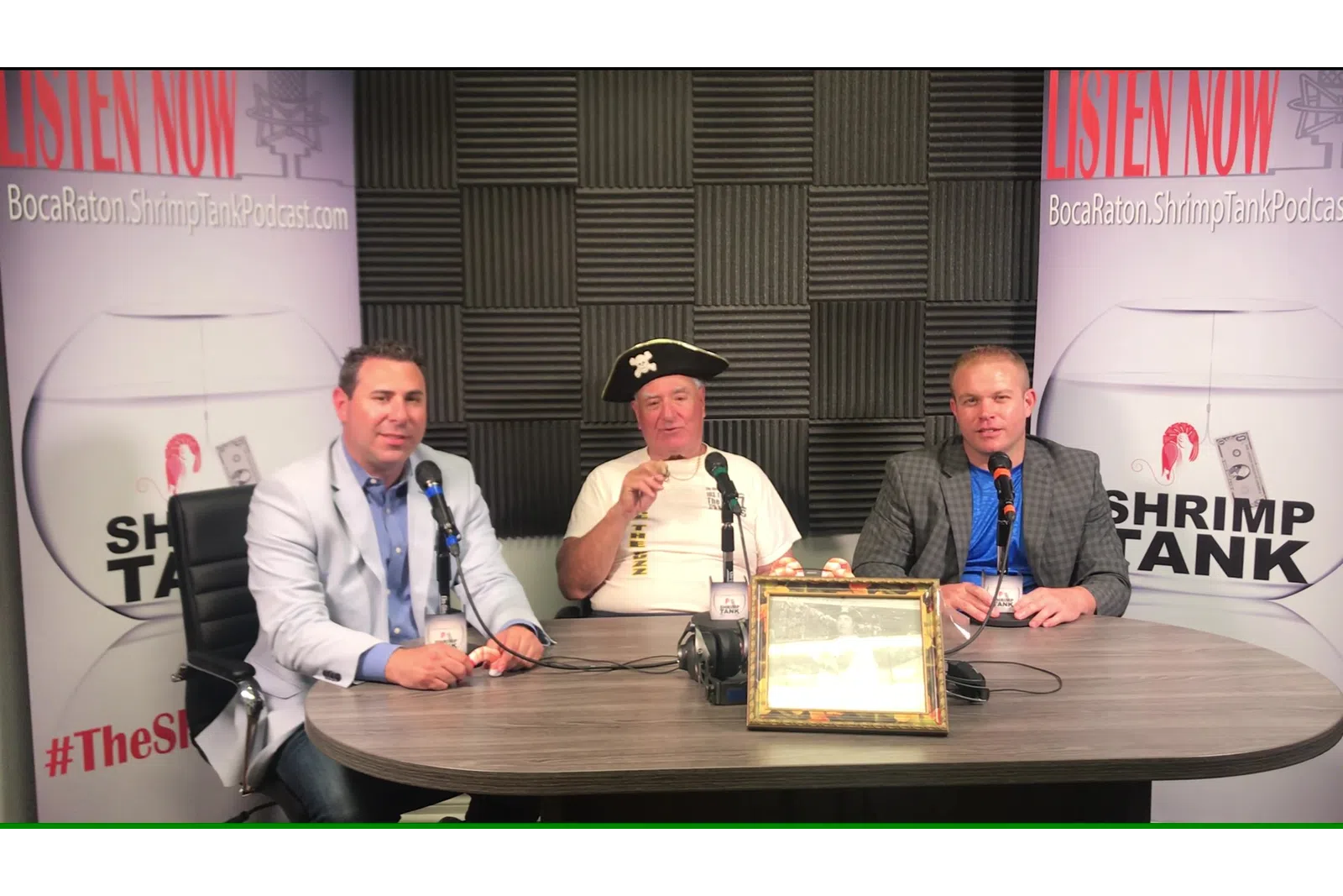 a group of men sitting at a table with microphones