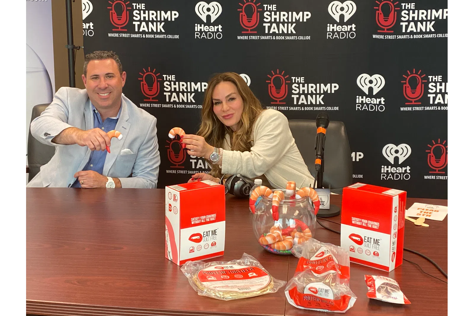 a man and a woman sitting at a table with food and drinks