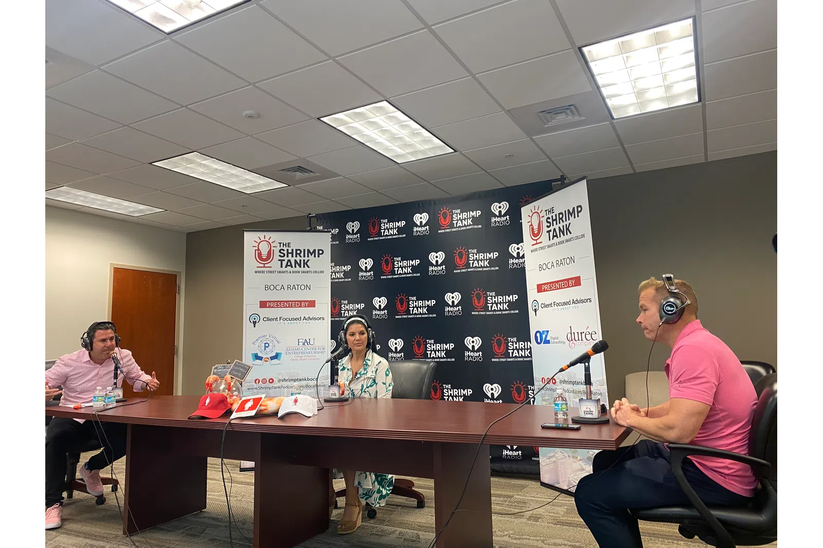 a group of people sitting at a table with microphones