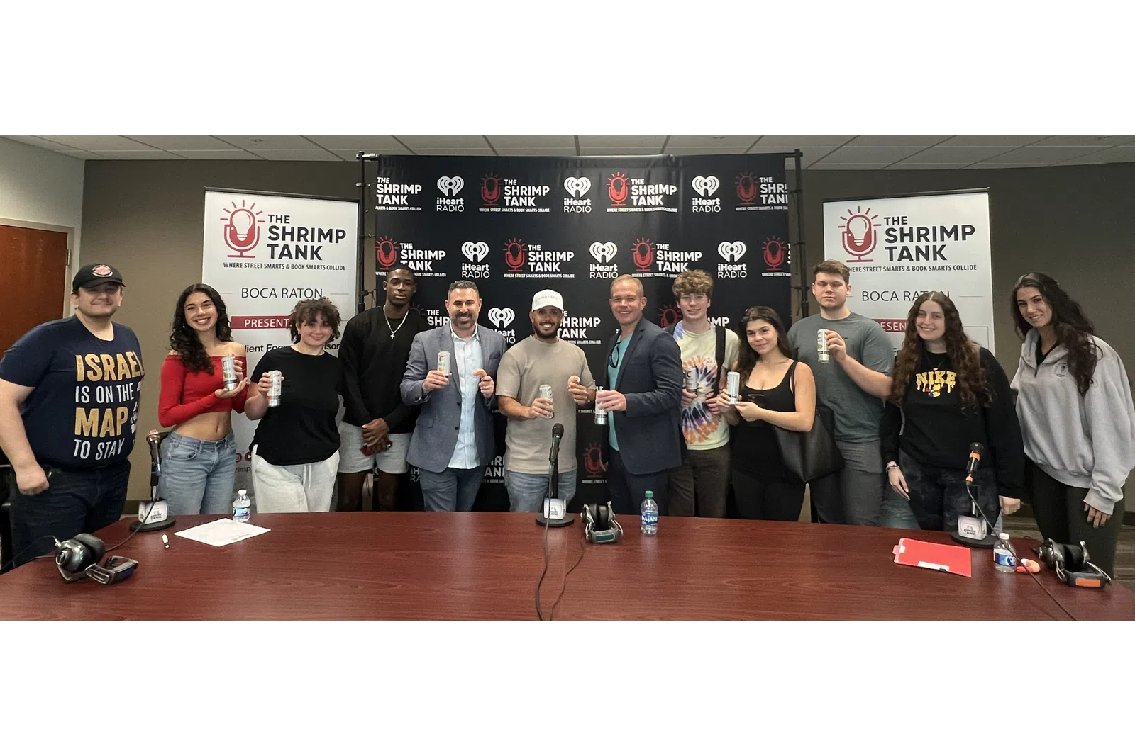 a group of people standing in front of a table with microphones