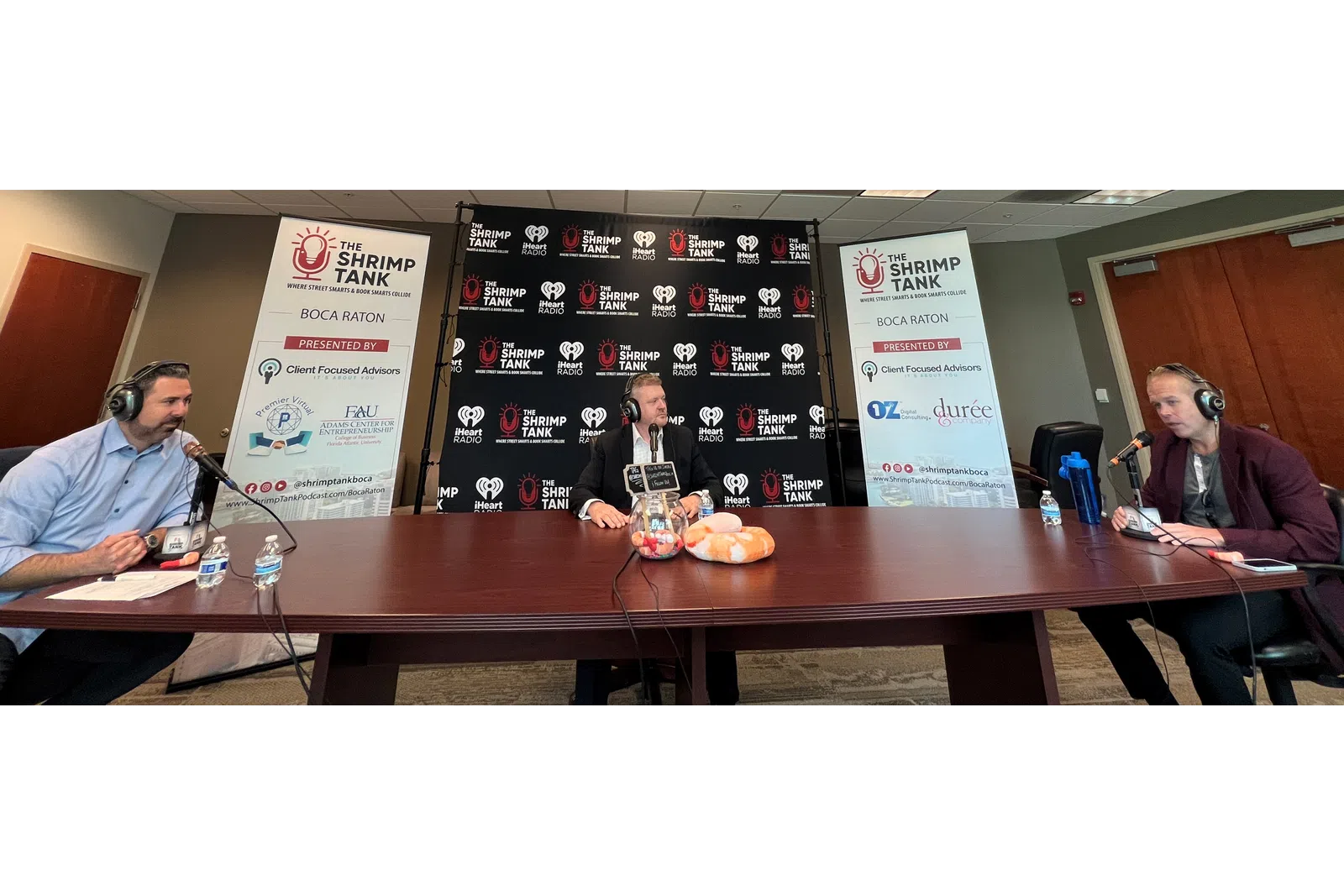 a group of people sitting at a table with microphones