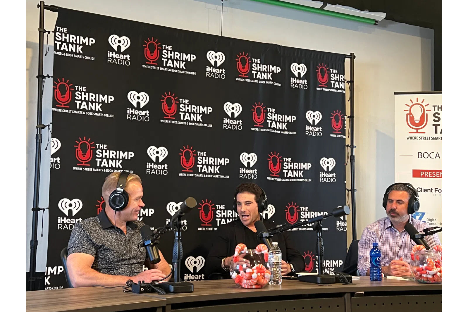 a group of men sitting at a table with microphones