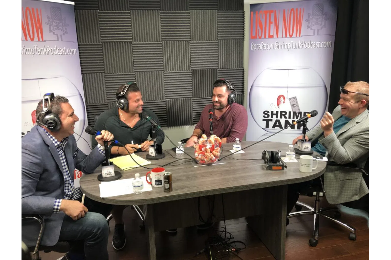 a group of men sitting at a table with headphones on
