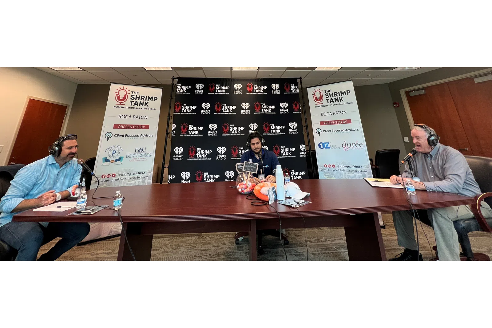 a group of people sitting at a table with microphones
