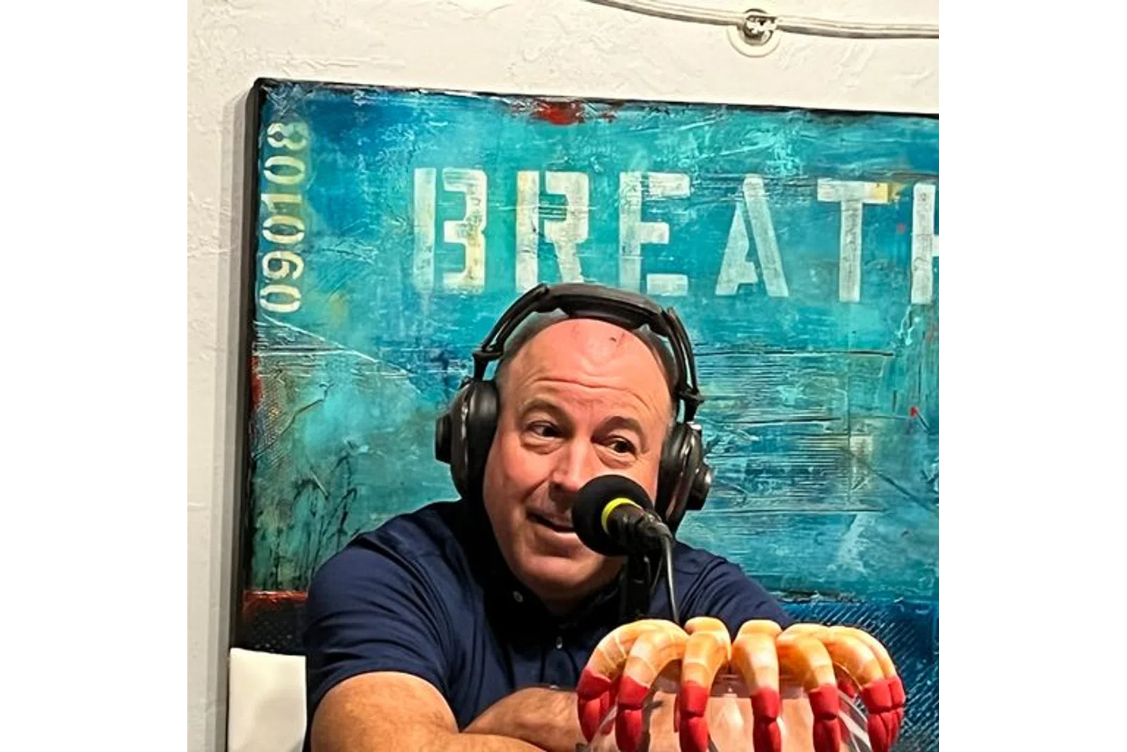 a man wearing headphones and holding a hot dog