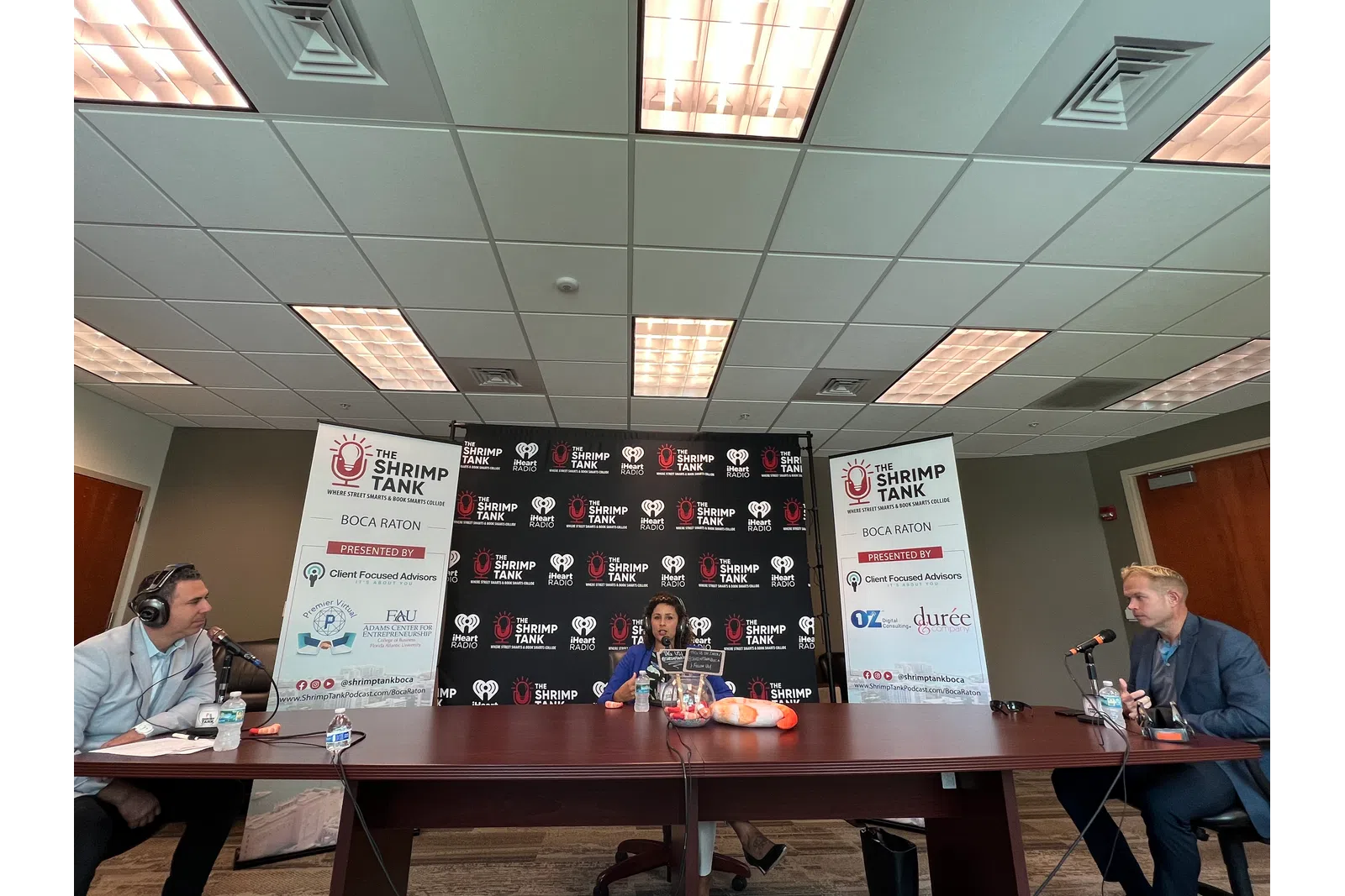 a group of people sitting at a table with microphones and signs