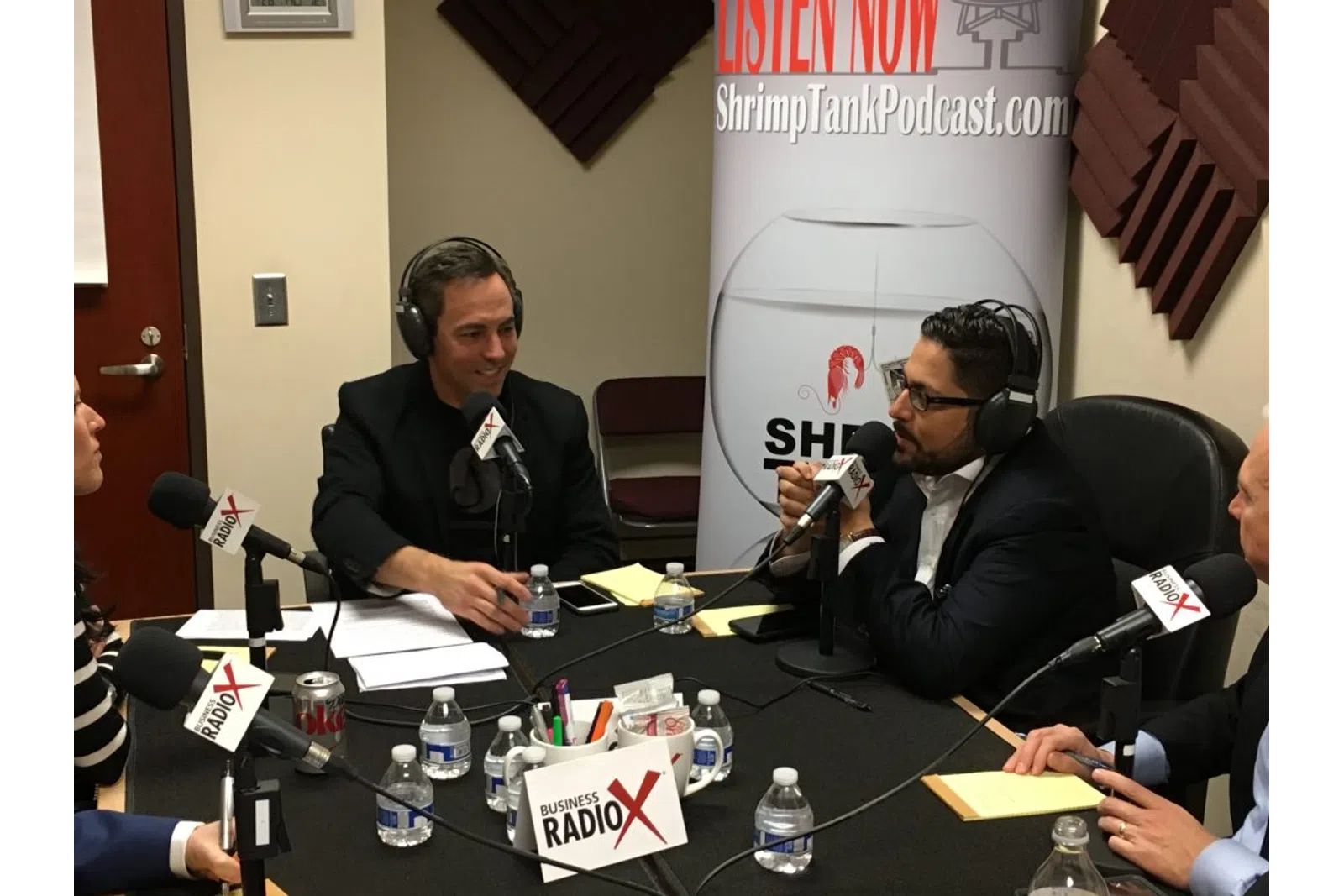 a group of men sitting at a table with microphones