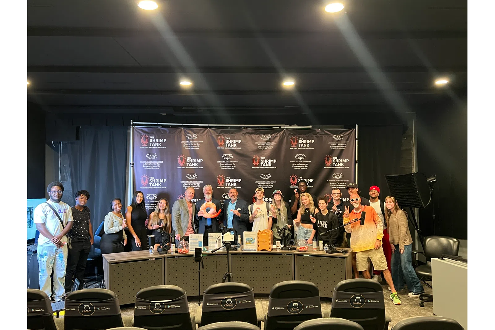 Participants gathered at a business event with a panel and branding backdrop.
