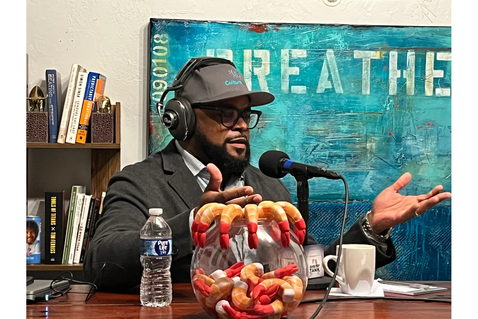a person wearing headphones and sitting at a desk with a microphone