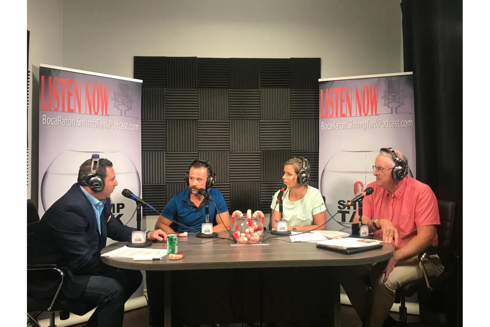 a group of people sitting at a table with microphones