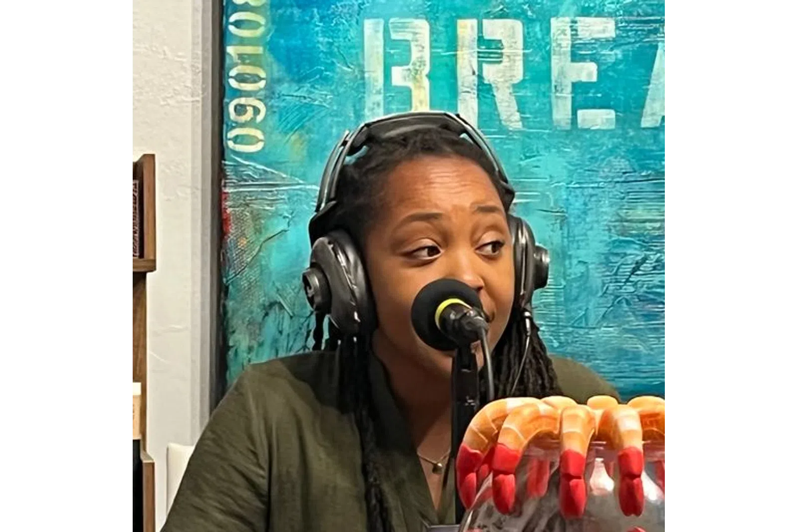 a woman wearing headphones and holding a hot dog