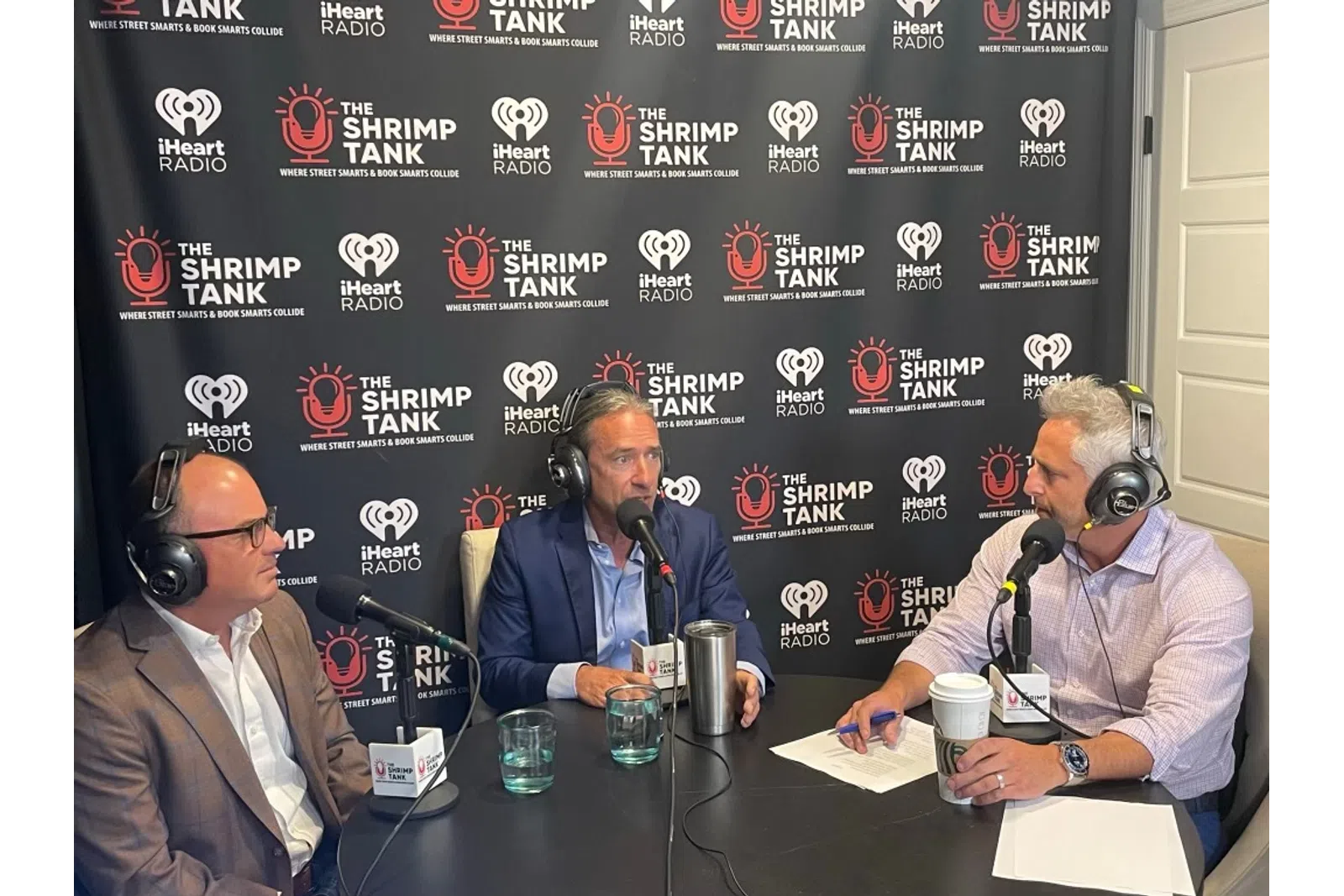 a group of men sitting at a table with microphones