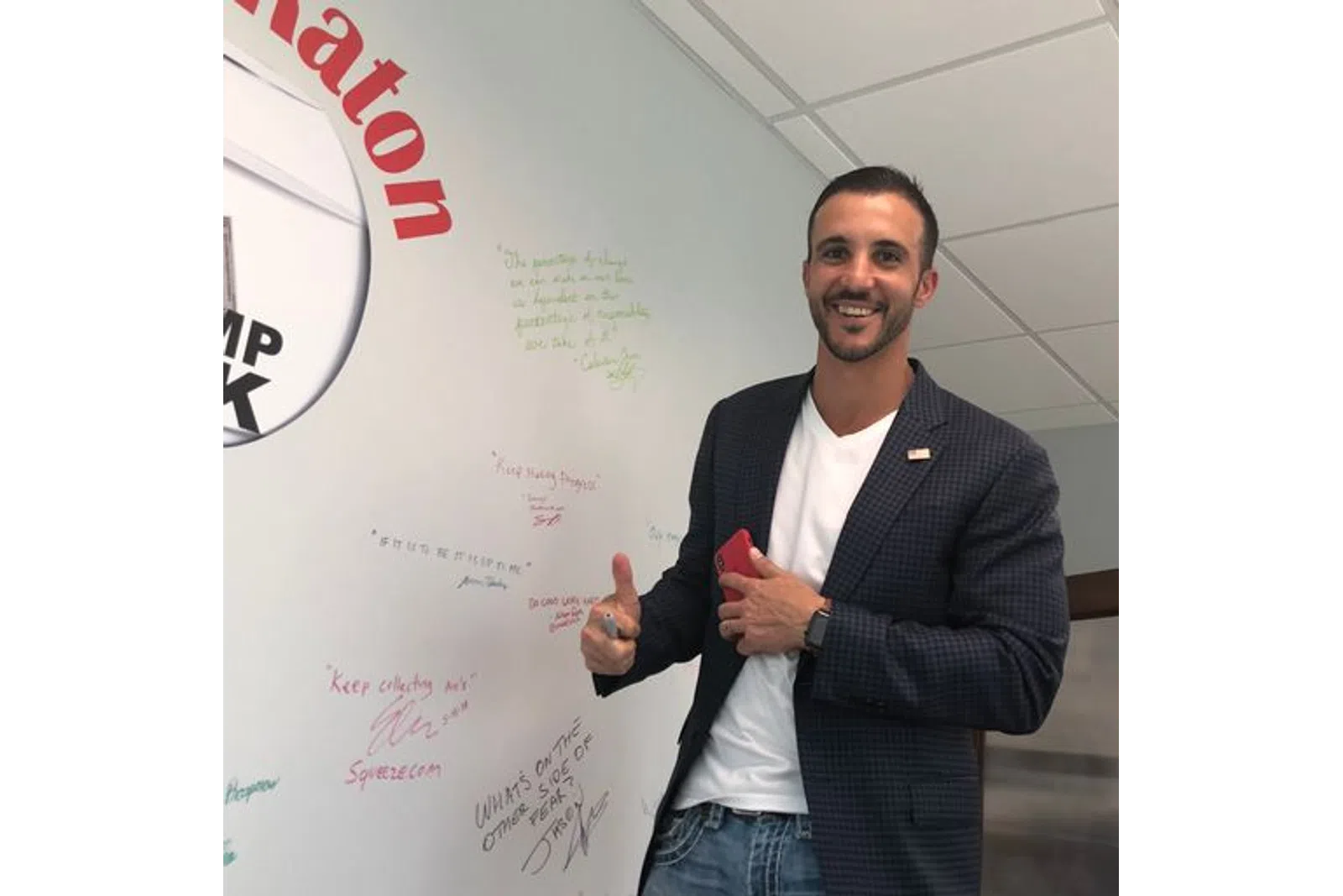 a person standing in front of a white board with writing on it