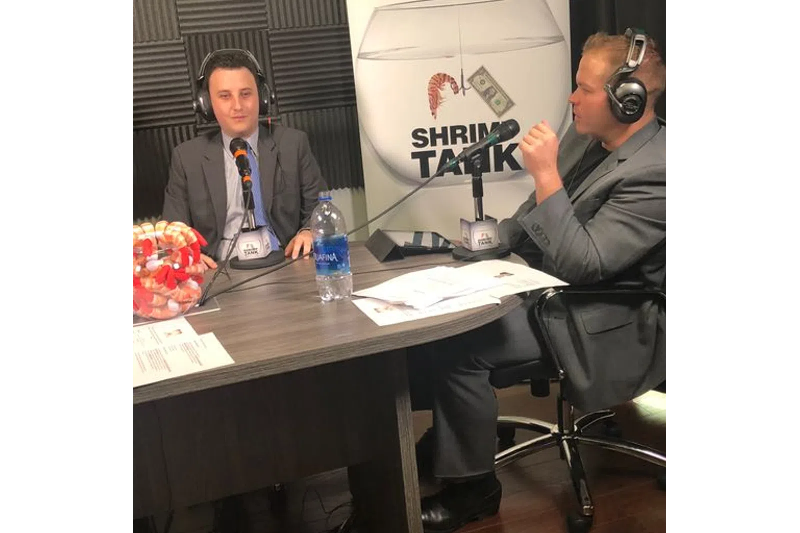 a man wearing headphones and sitting at a table with a microphone