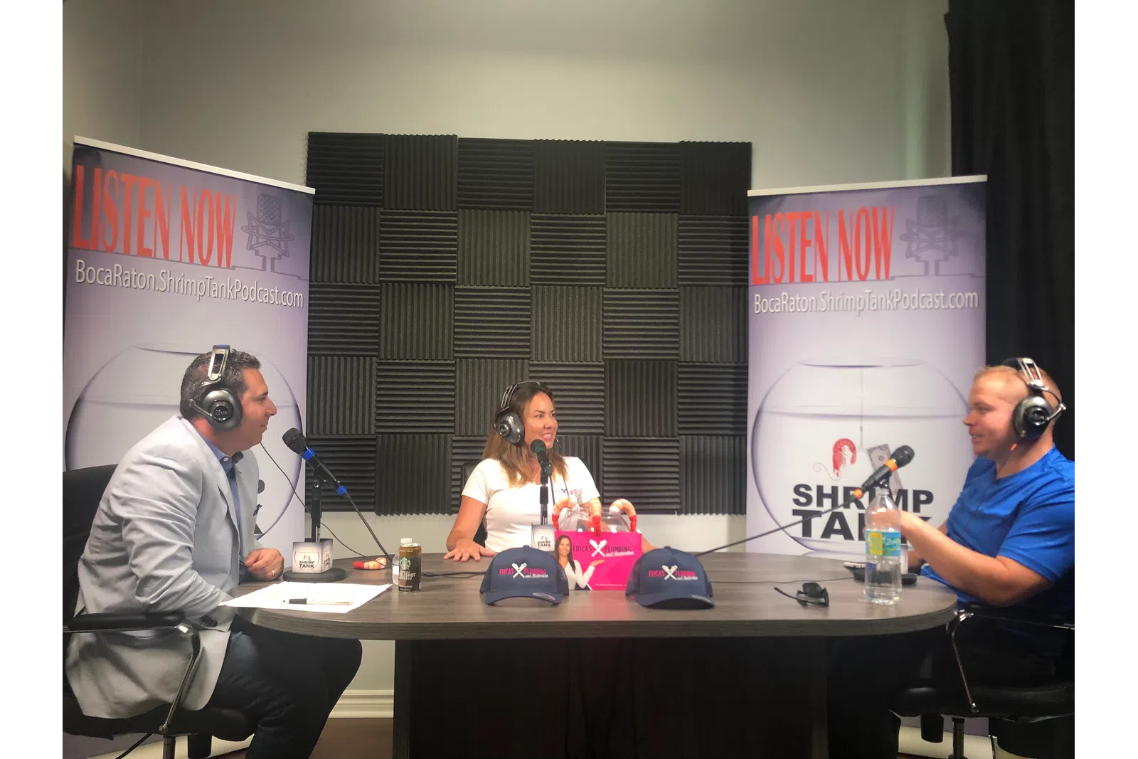 a group of people sitting at a table with microphones