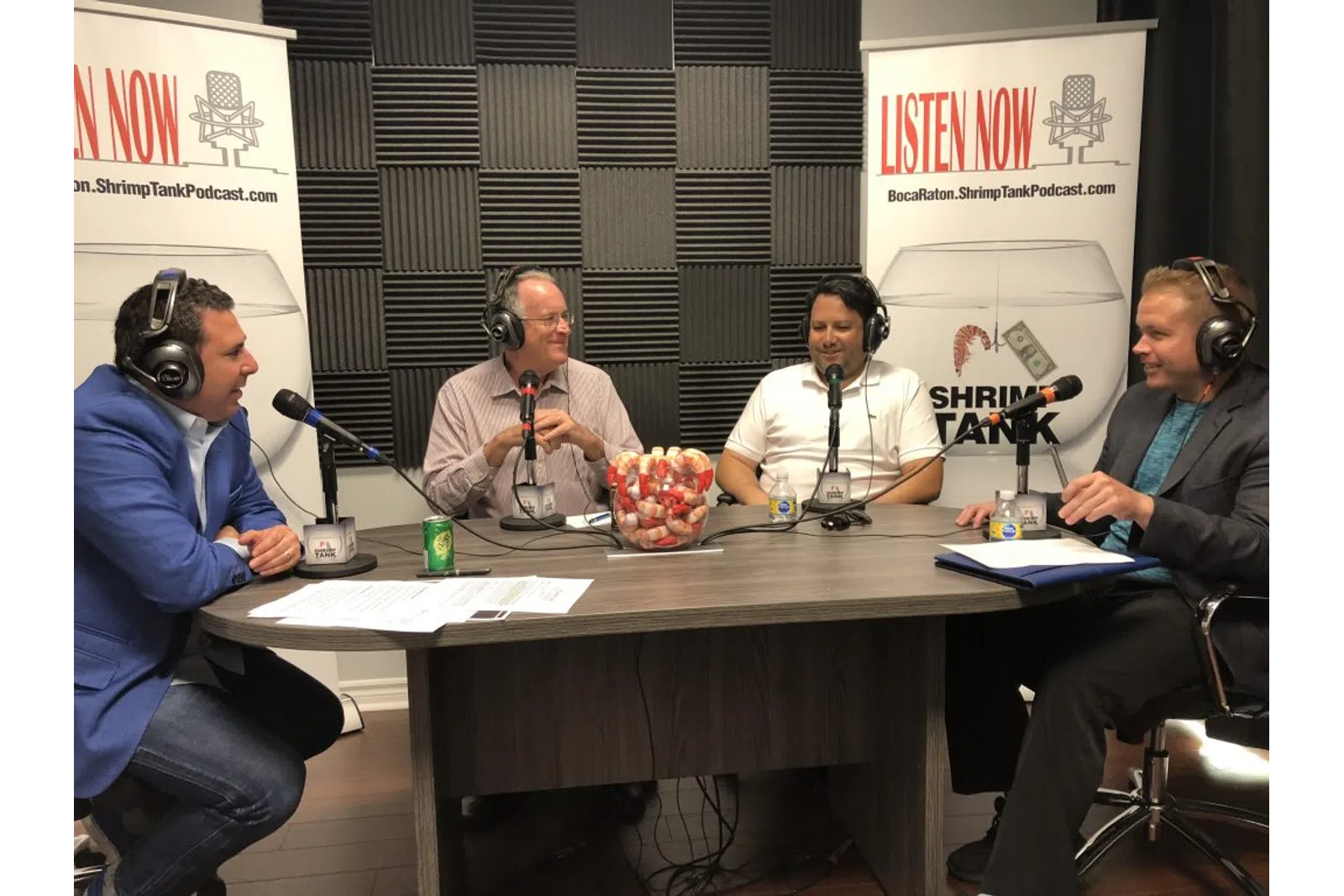 a group of people sitting at a table with microphones