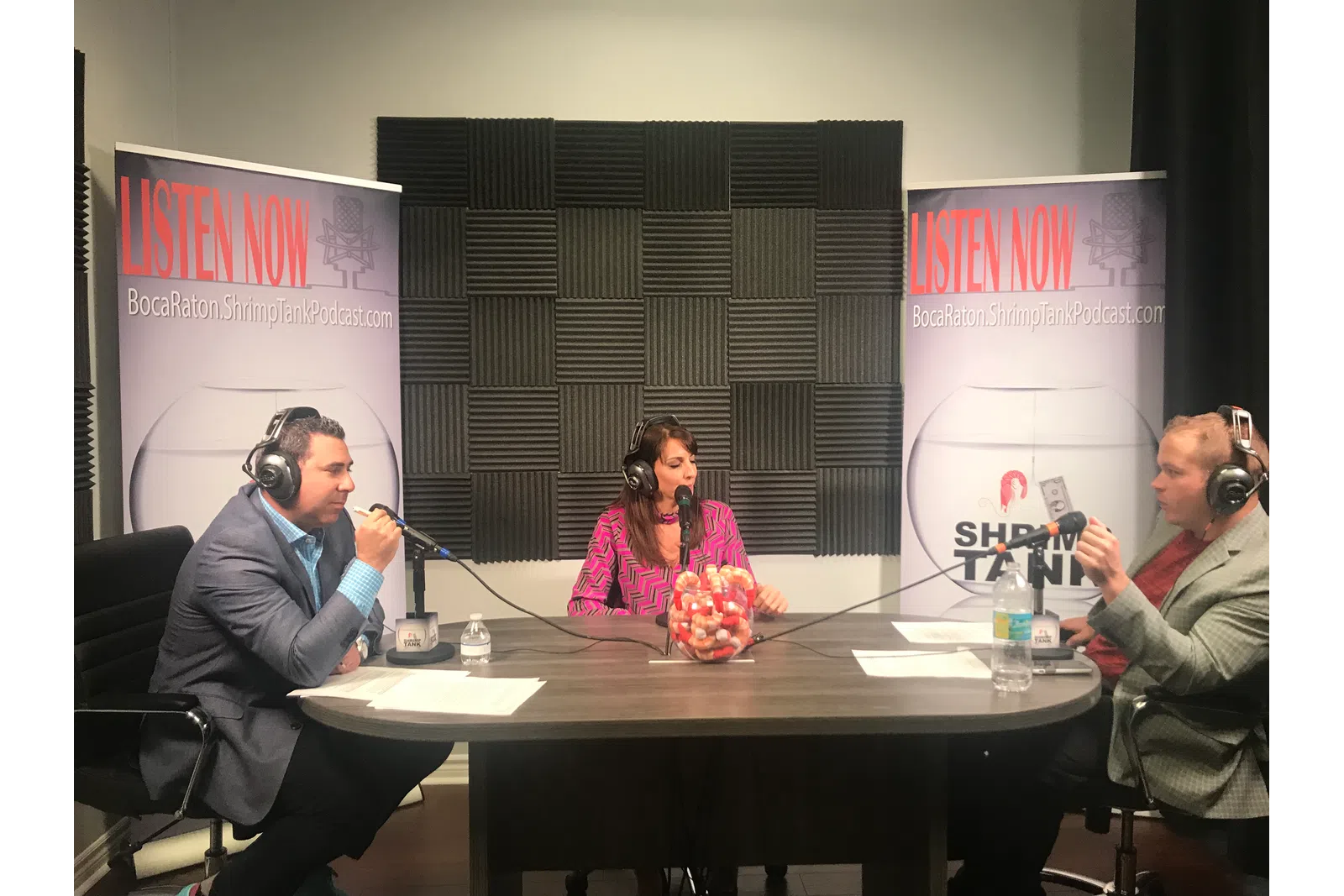 a group of people sitting at a table with microphones