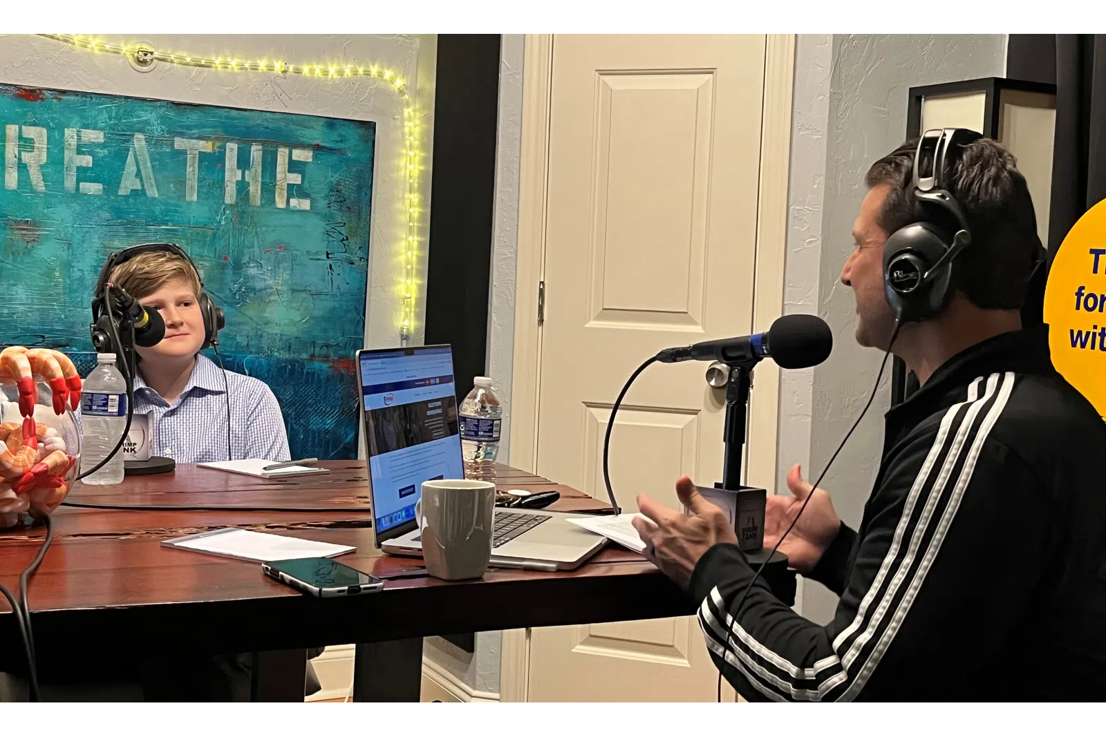 a man wearing headphones and sitting at a table with a woman