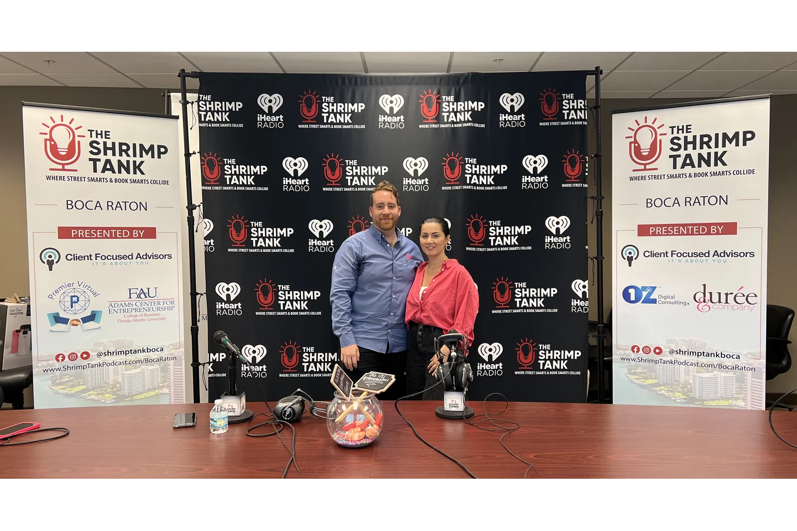 a man and woman standing next to a table with a trophy