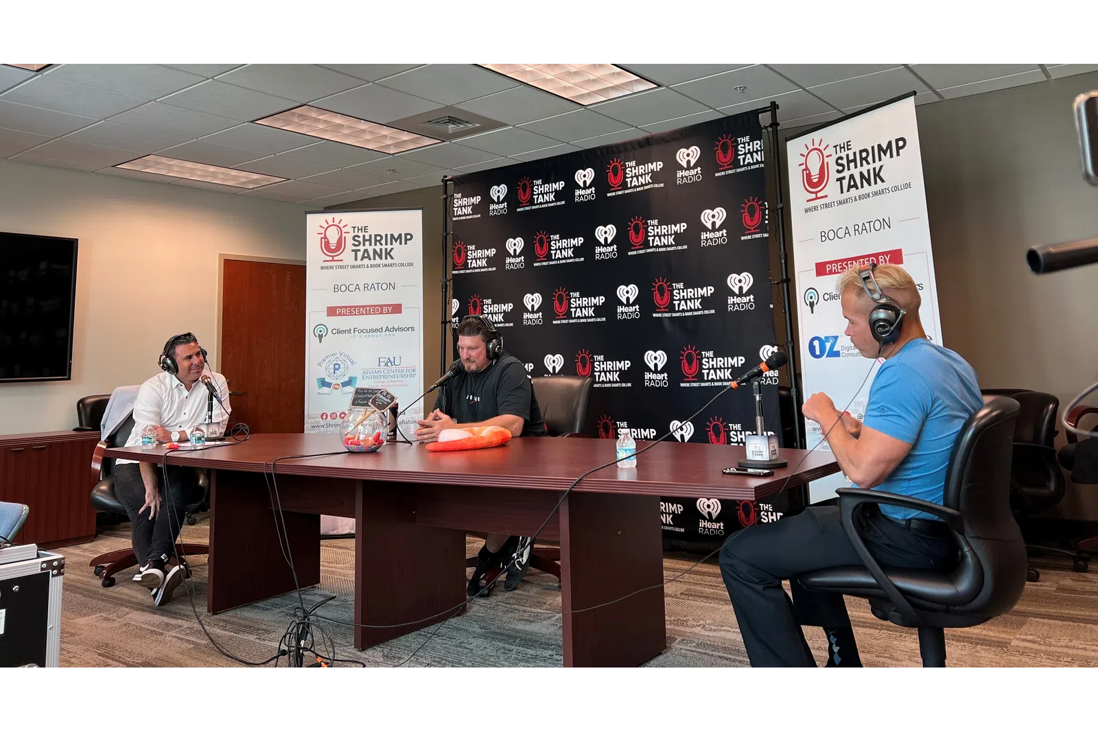 a group of people sitting at a table with headphones on