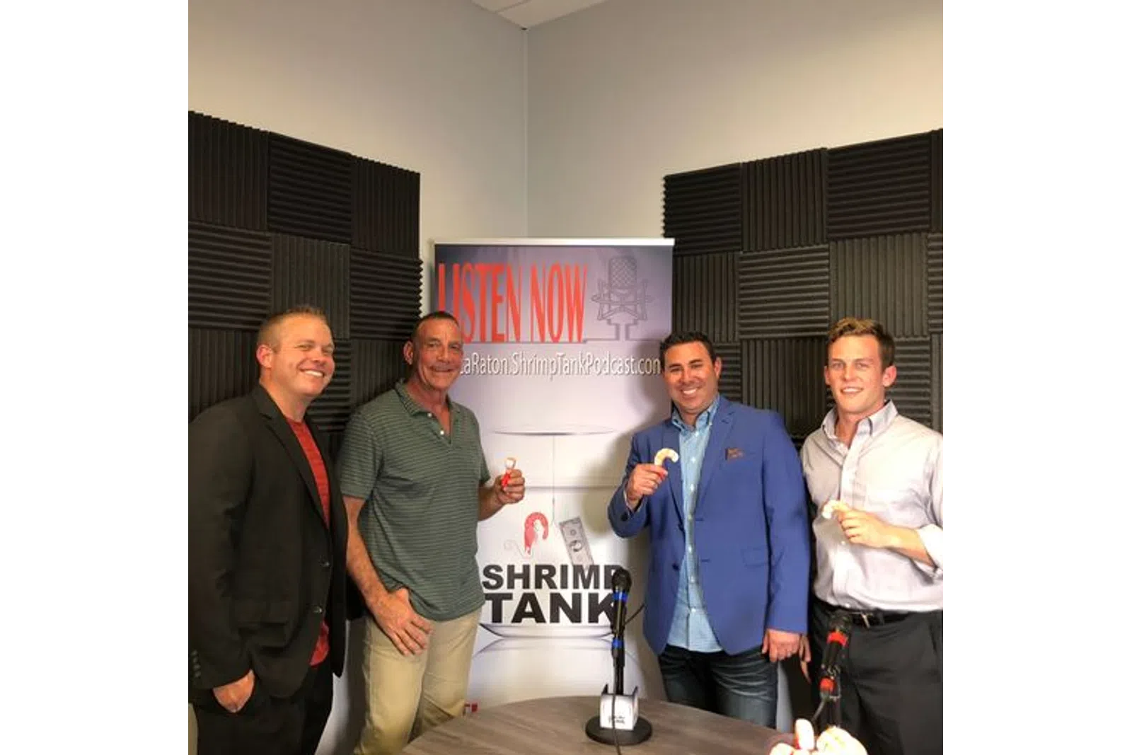 a group of men standing in front of a sign