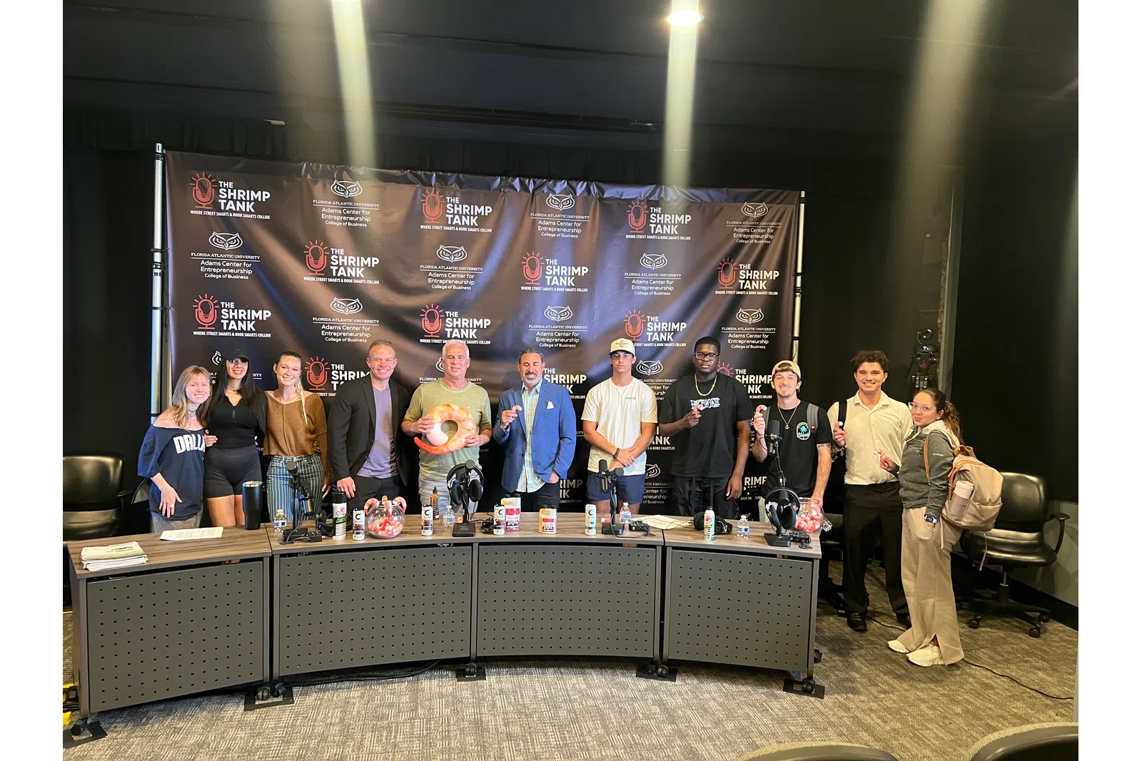 a group of people standing in front of a table with drinks