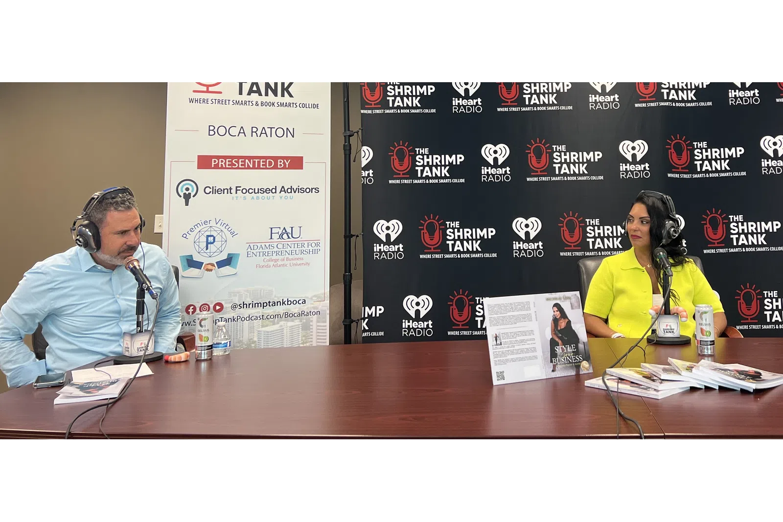a man and woman sitting at a table with microphones