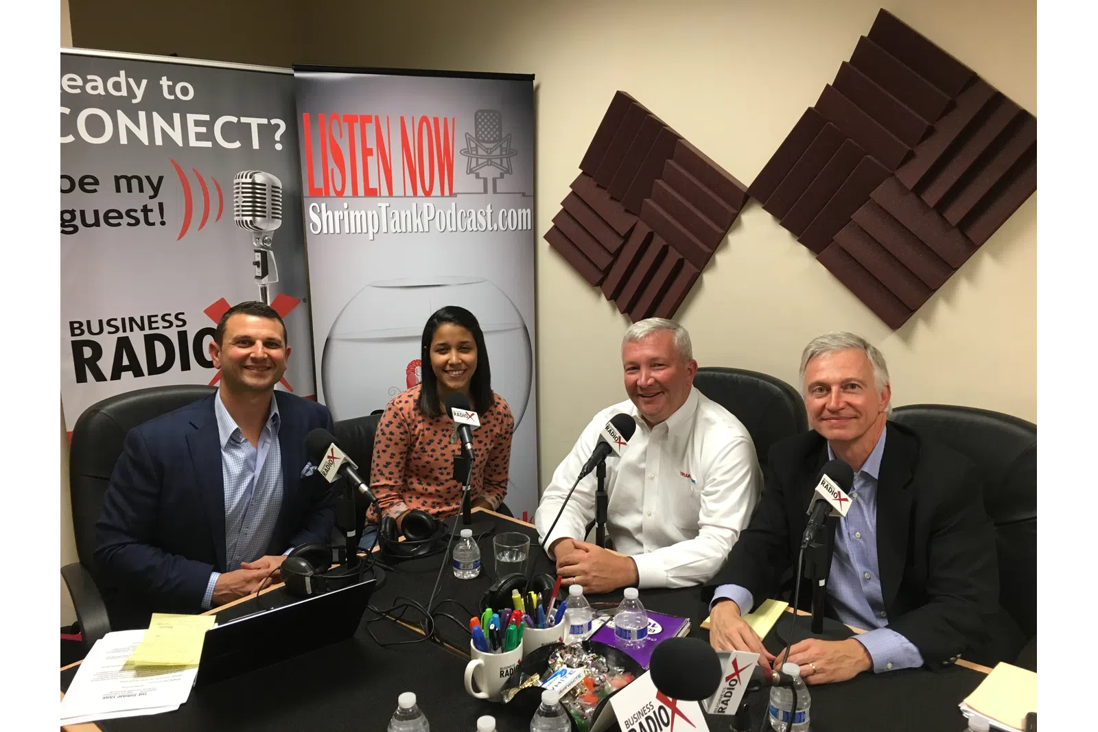a group of people sitting at a table with microphones