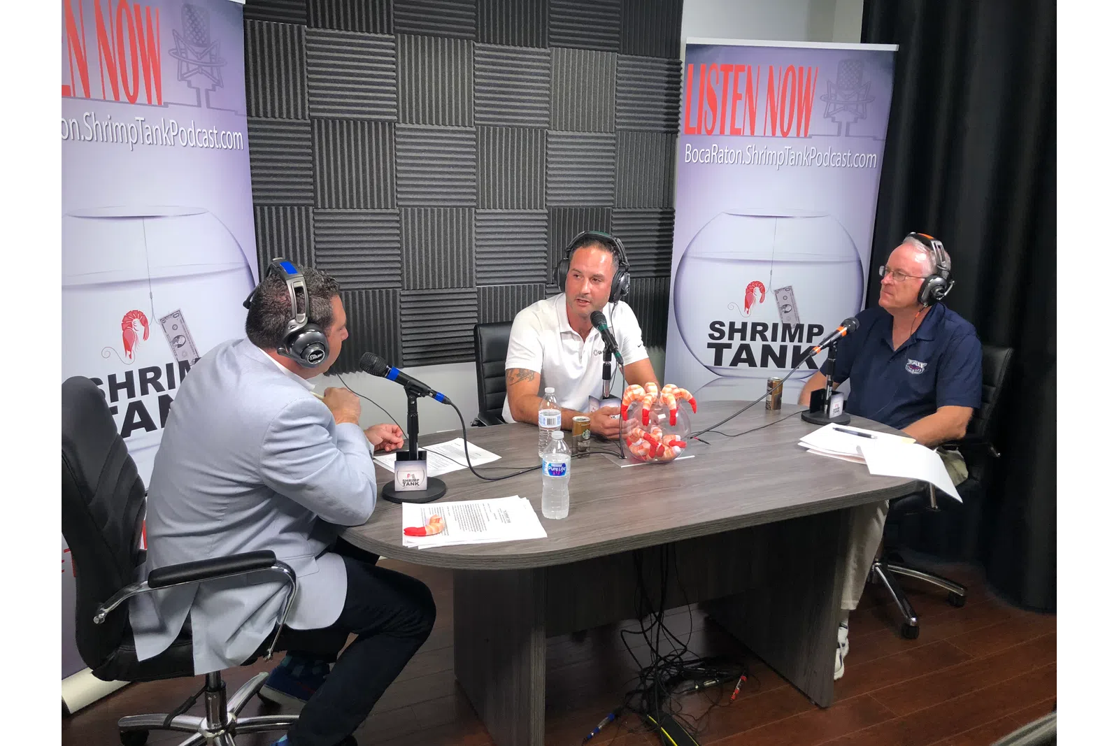 a group of people sitting at a table with microphones