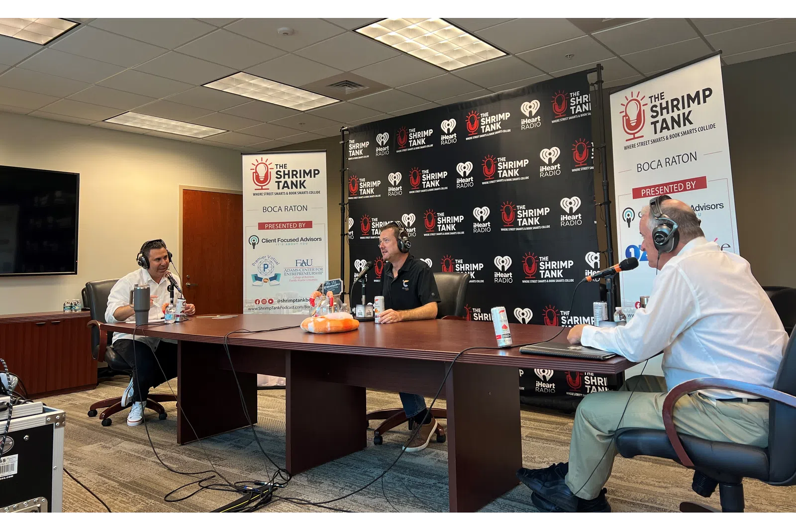 a group of people sitting at a table with microphones