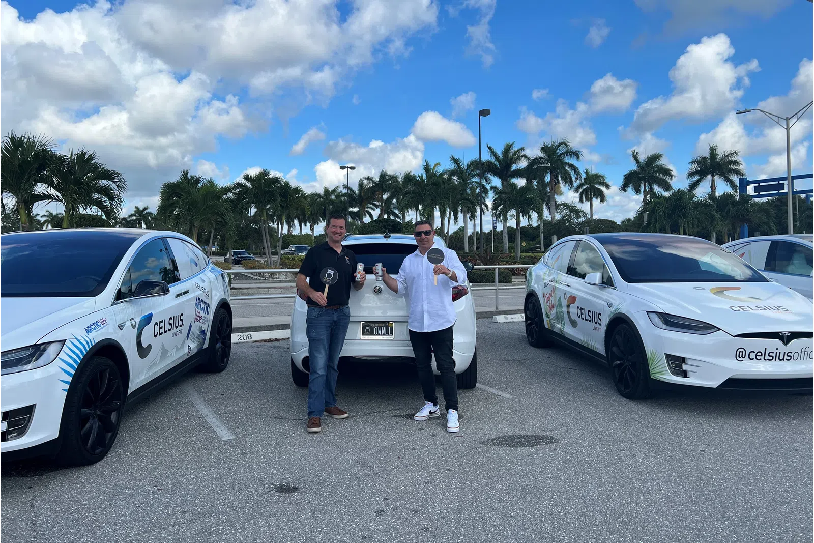 a group of men standing next to a car in a parking lot