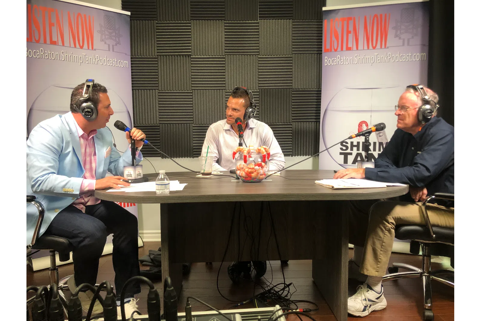 a group of people sitting at a table with microphones