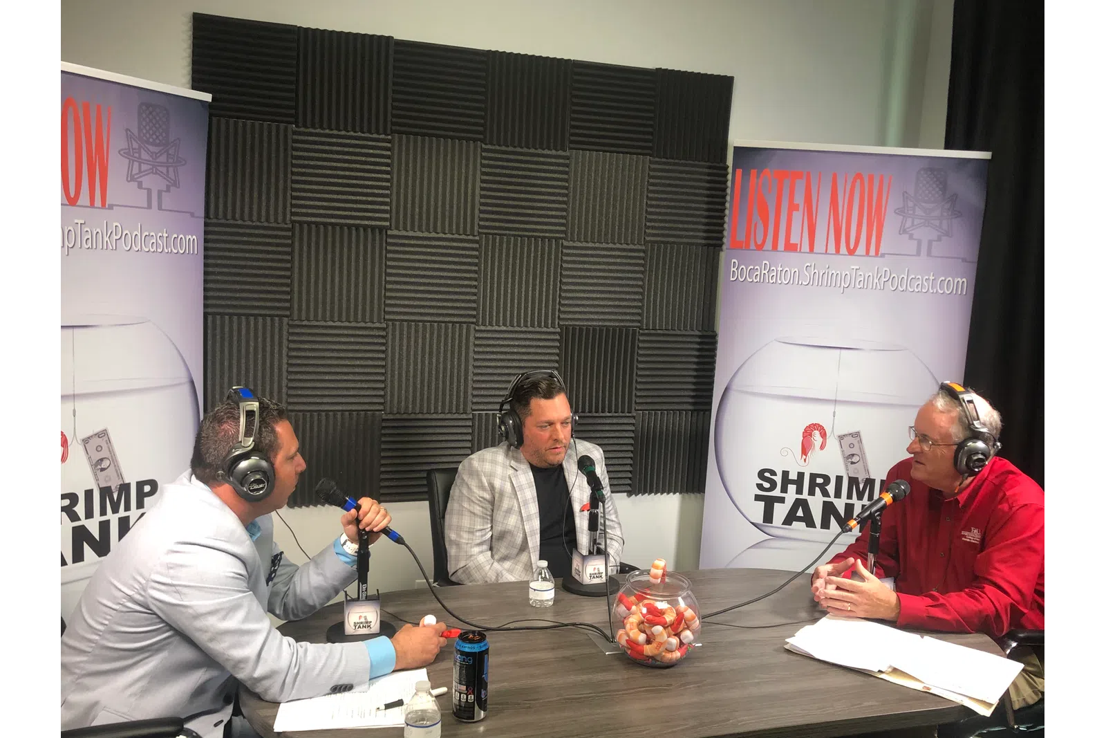 Vaughan Dugan et al. sitting at a table with microphones