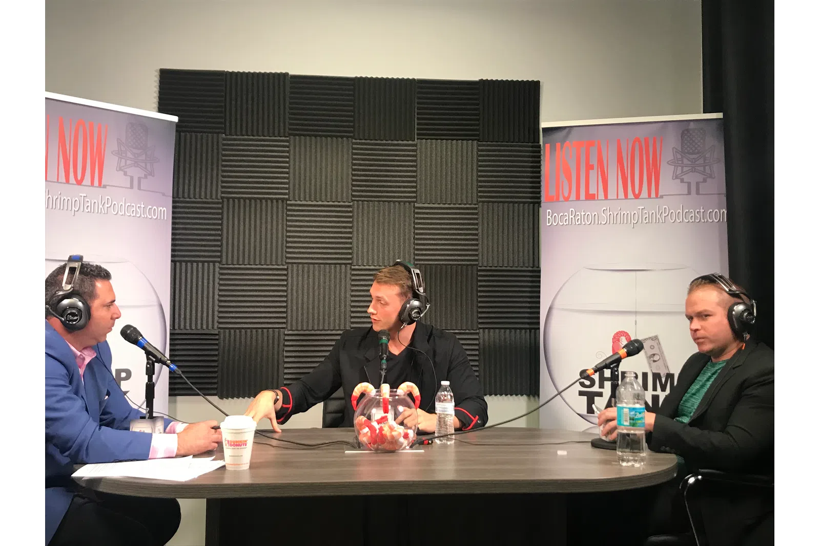 a group of people sitting at a table with microphones