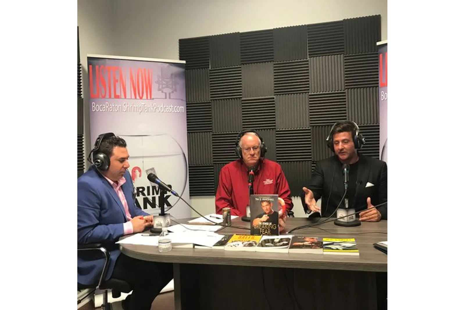 a group of men sitting at a table with microphones