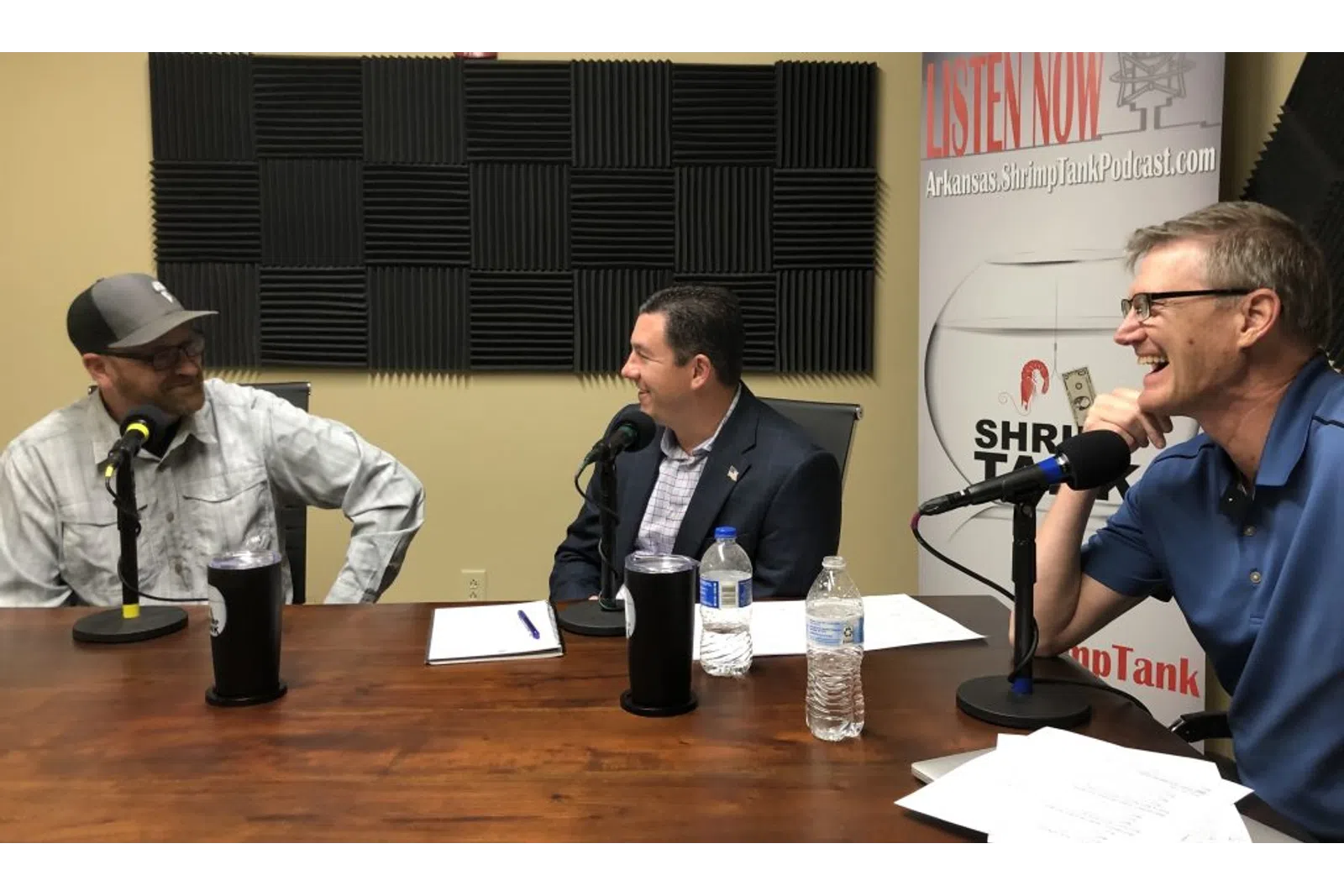 a group of men sitting at a table with microphones
