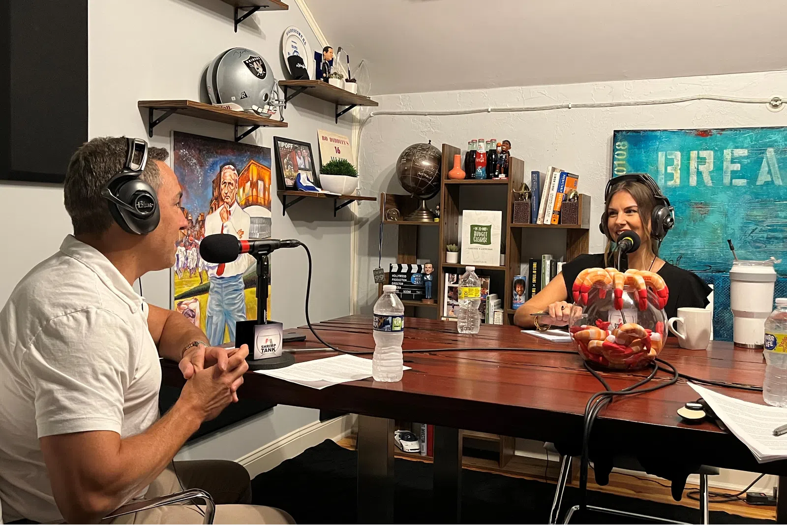 a man wearing headphones and sitting at a table with a woman in a chair