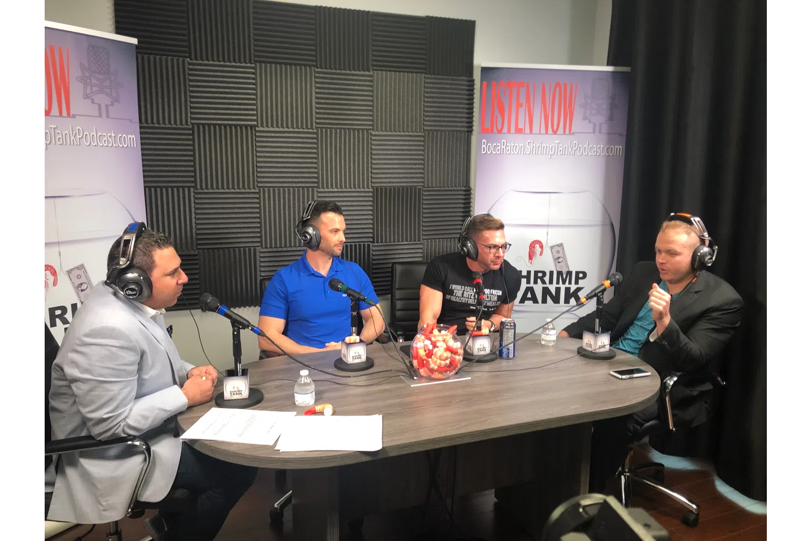 a group of people sitting at a table with microphones