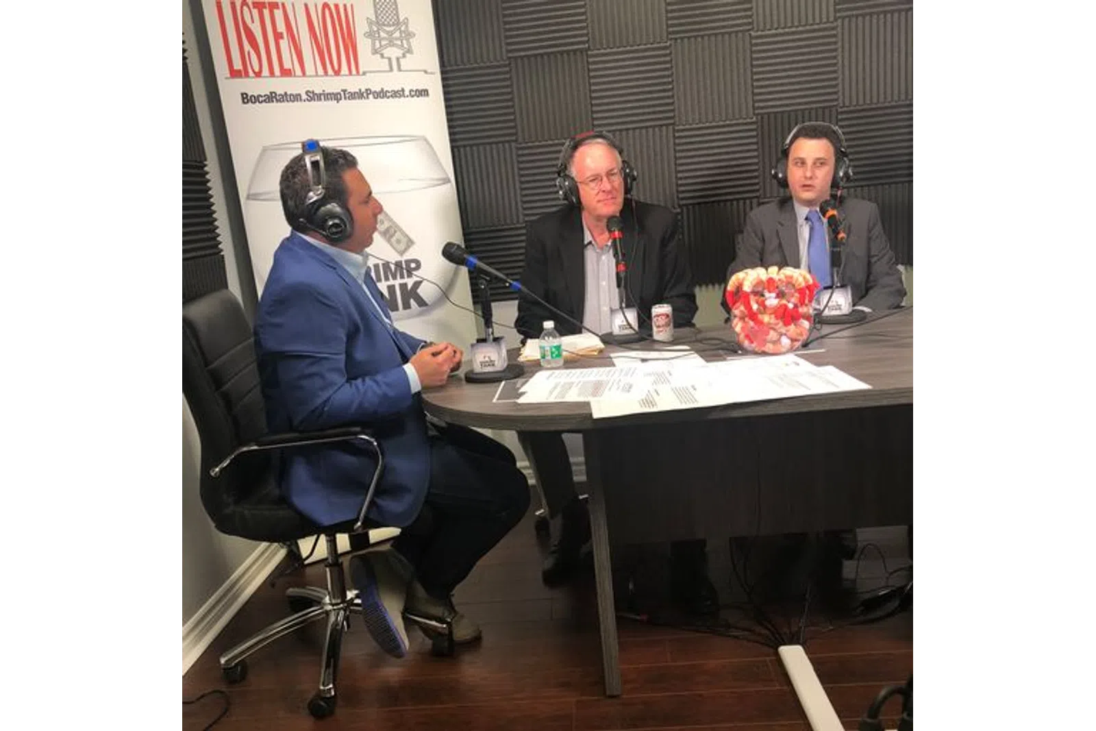 a group of men sitting at a table with microphones