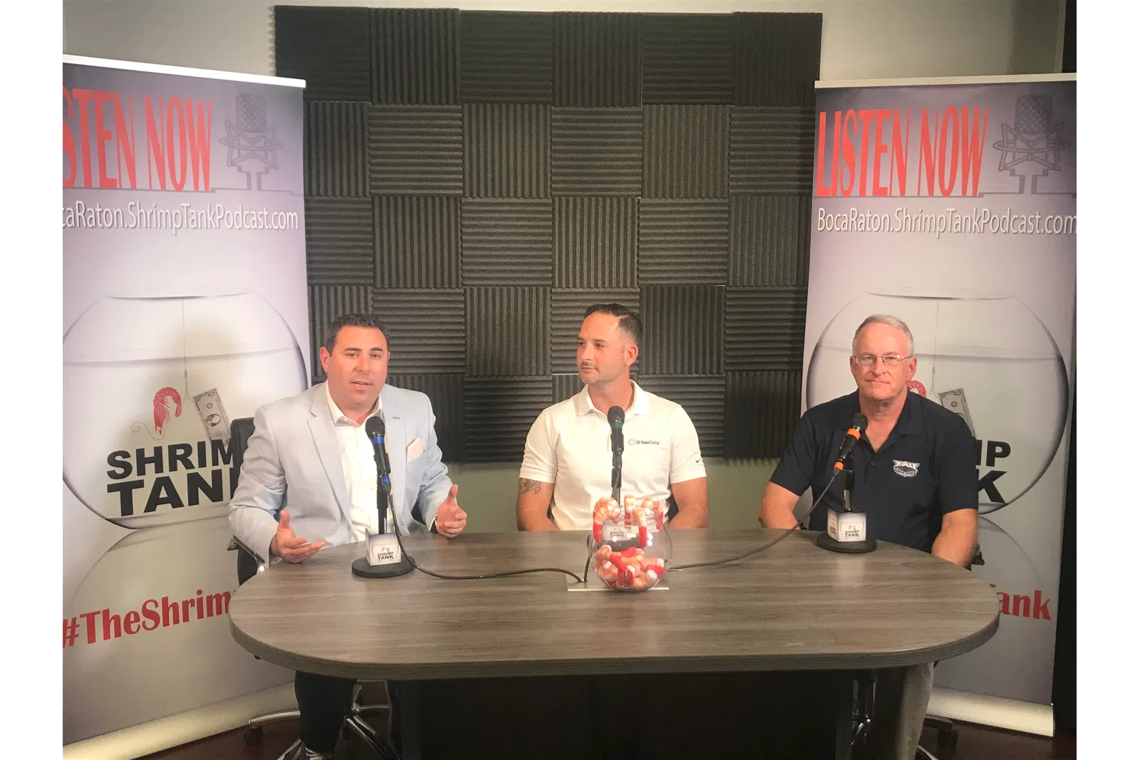 a group of men sitting at a table with microphones