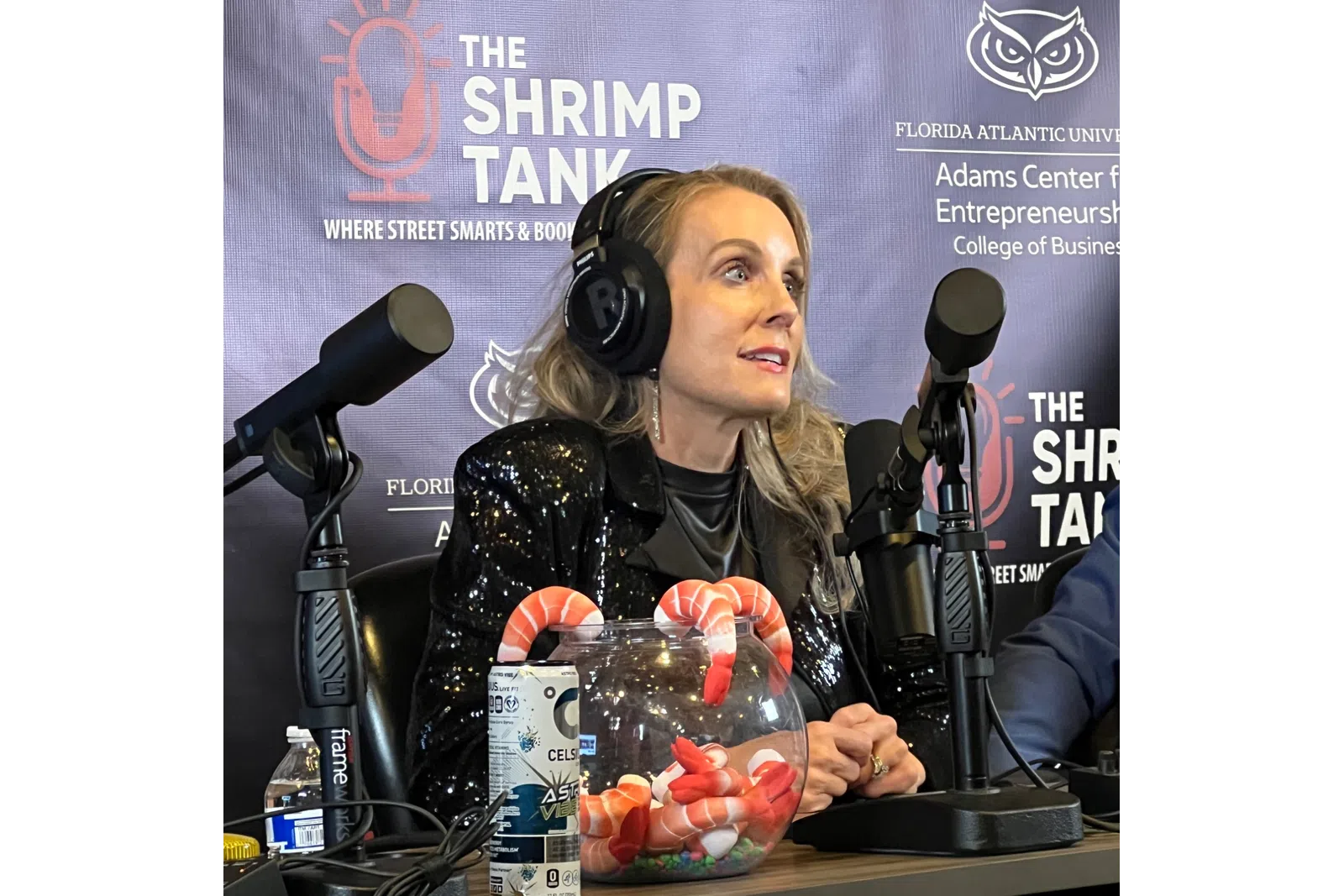 Woman with headphones speaking into microphone during The Shrimp Tank podcast at Florida Atlantic University
