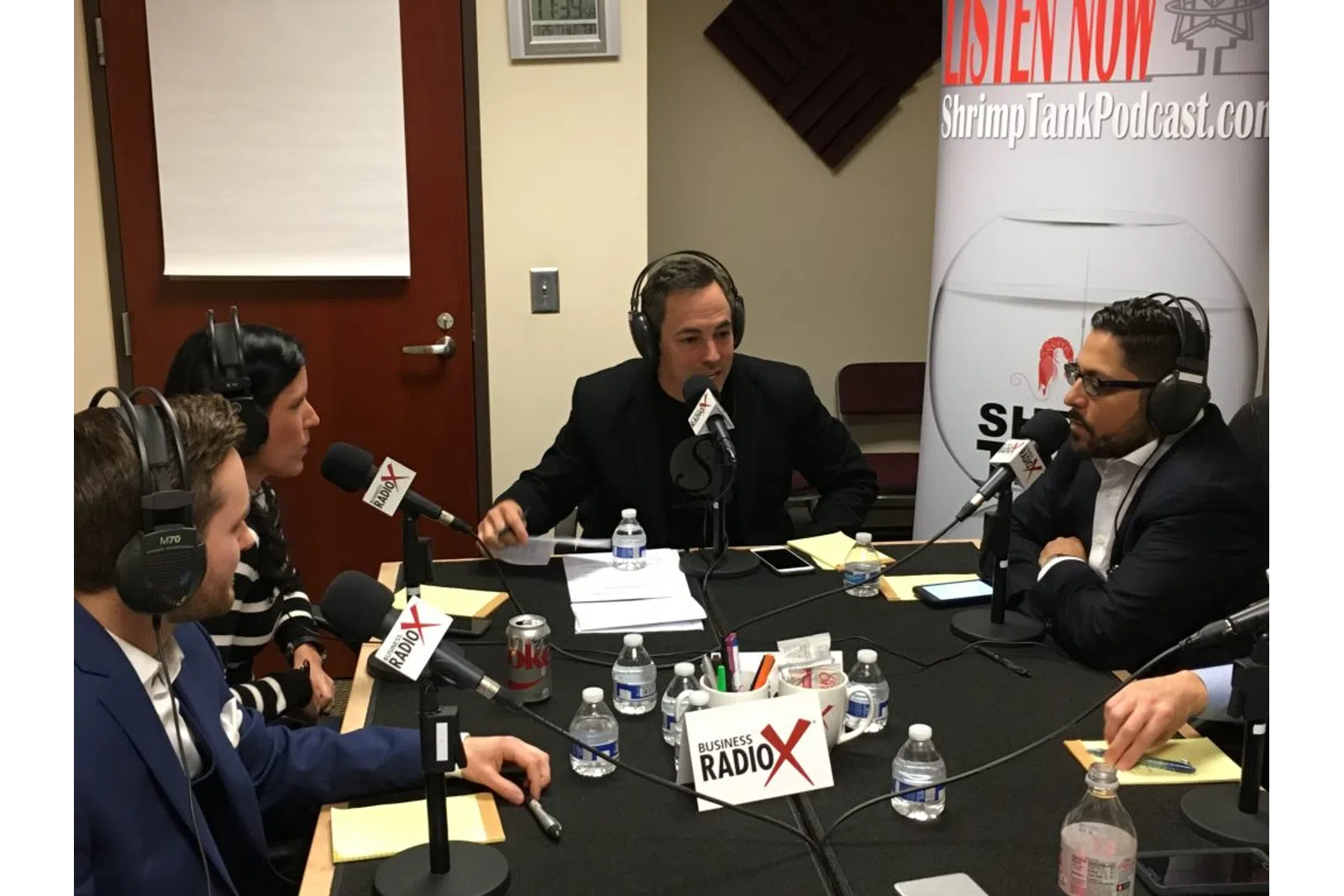 a group of people sitting at a table with microphones