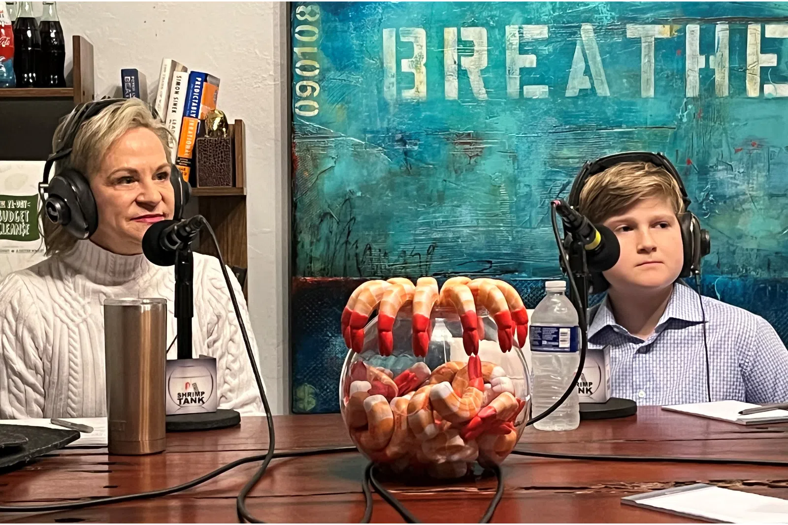a couple of women wearing headphones and sitting at a table with a basket of food