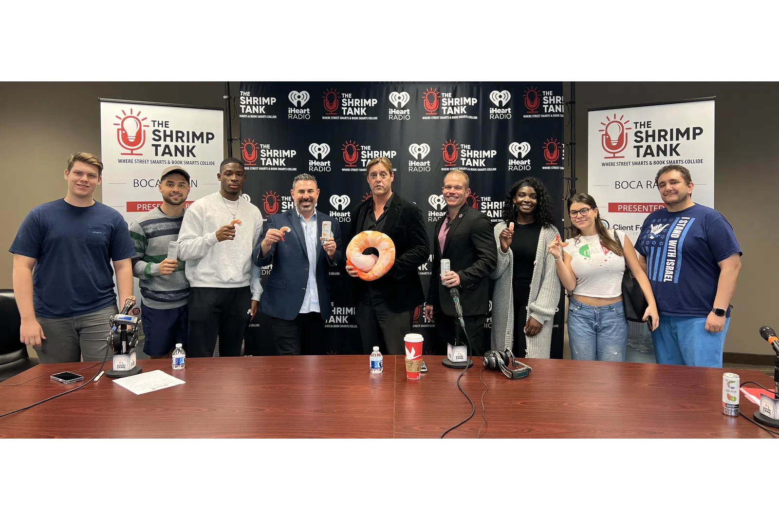a group of people standing in front of a table with microphones