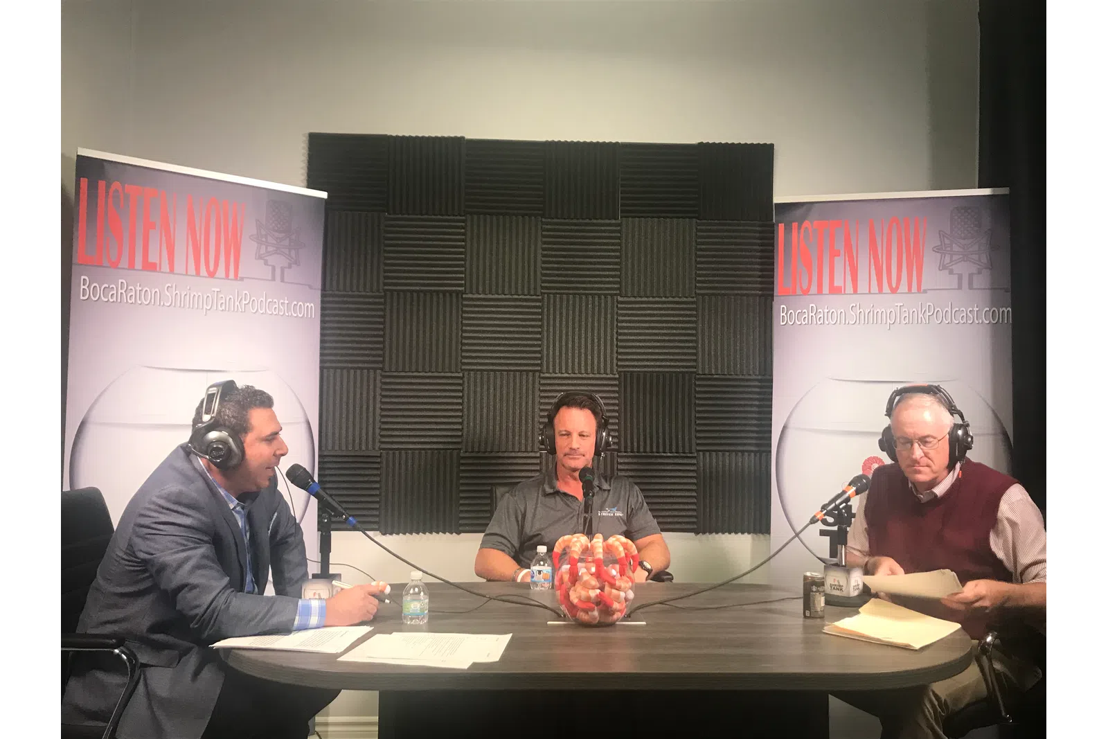 a group of people sitting at a table with microphones