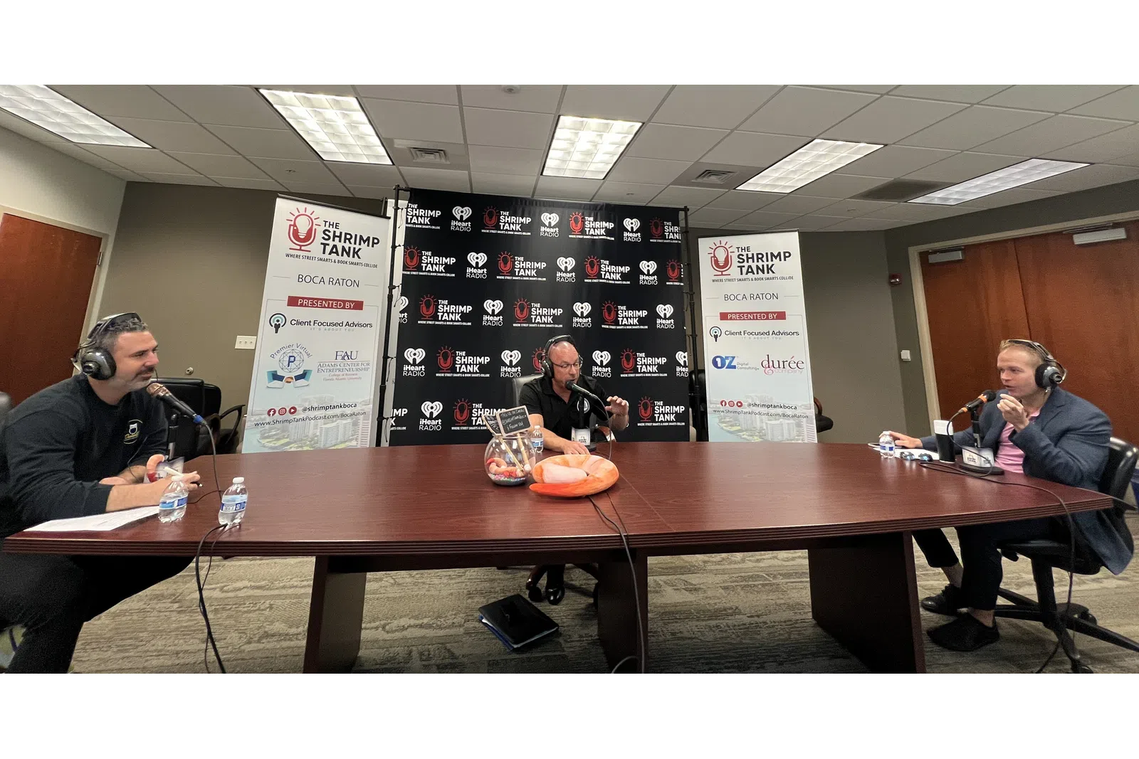a group of people sitting at a table with microphones