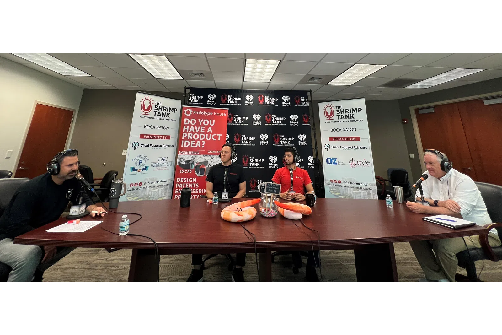 a group of people sitting at a table with microphones