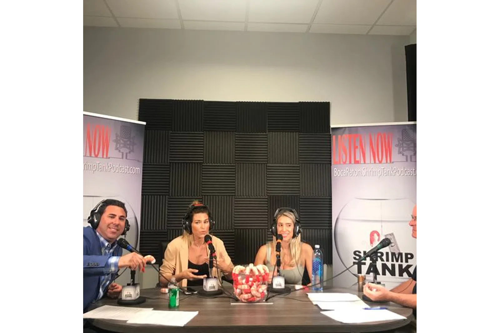 a group of people sitting at a table with microphones
