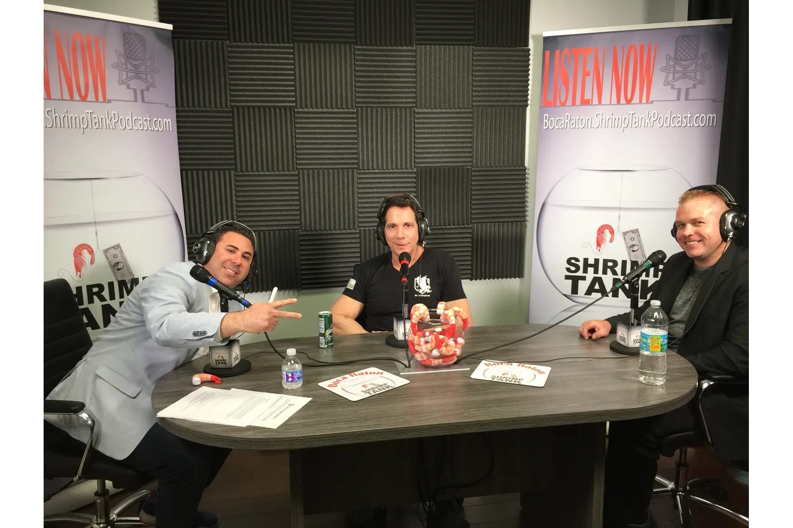 a group of people sitting at a table with microphones